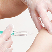 Impfung miit Spritze in den Oberarm